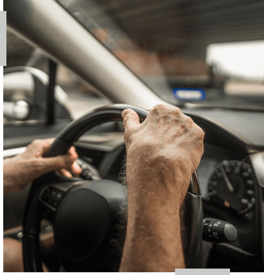 Hands gripping a car steering wheel.