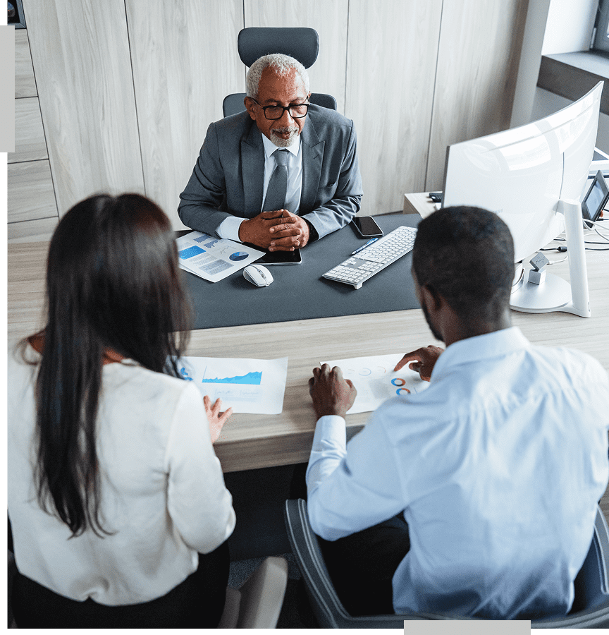 Business meeting with three professionals at desk.